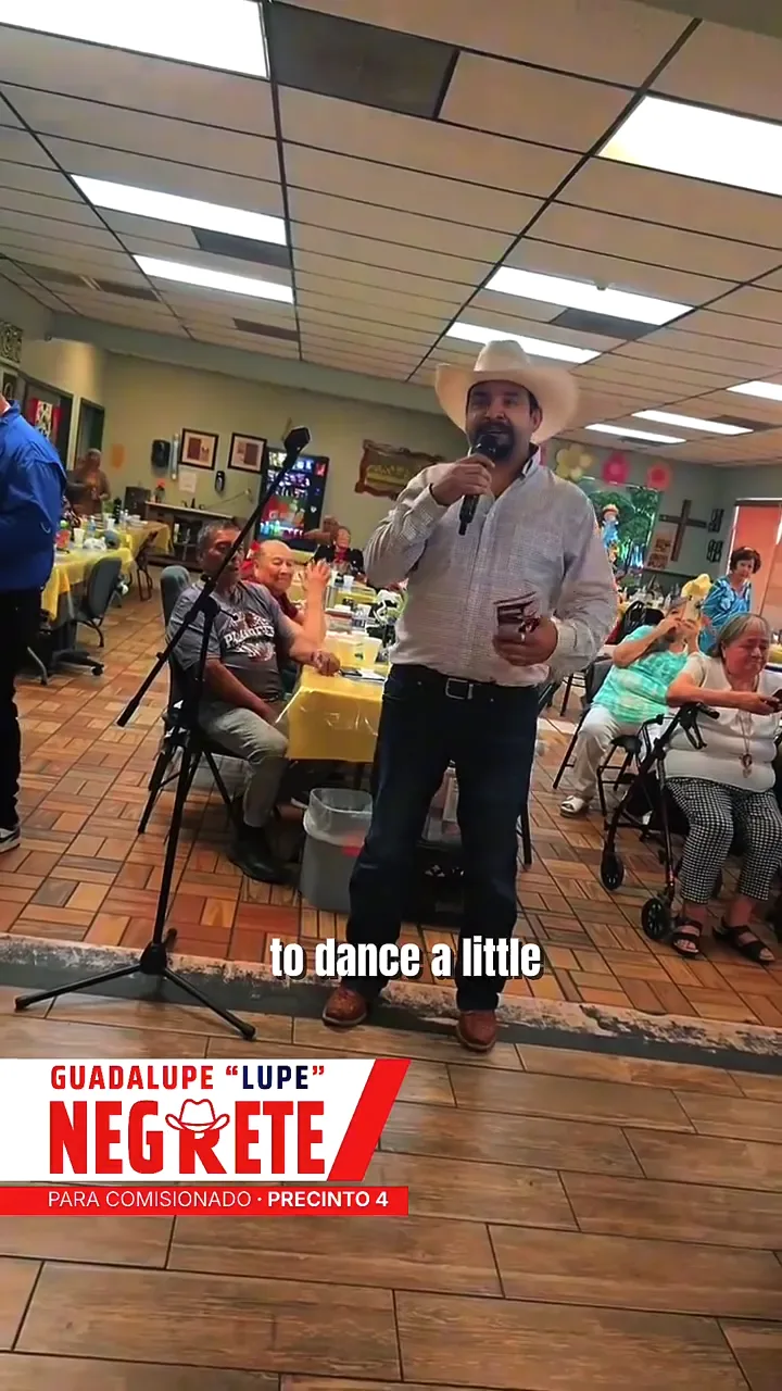Lupe Negrete con micrófono hablando ante vecinos