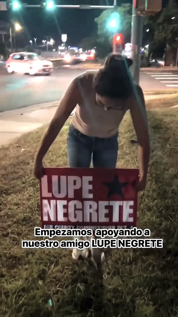 Un vecino instalando un letrero de campaña de Lupe Negrete